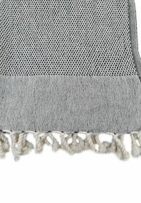 Eine grau-schwarze gewebte Decke mit einem strukturierten Muster und fransigen Kanten. Das Material wirkt weich und strapazierfähig.