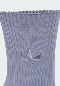 Light purple ribbed sock with a soft texture, featuring a small embroidered logo of three leaves near the top. Clear, vertical stripes.