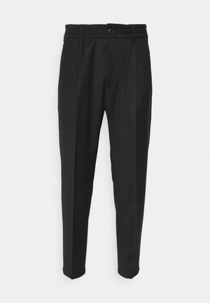 Black trousers made of textured fabric, featuring a button closure, elastic waistband, two front pockets, and tapered legs.