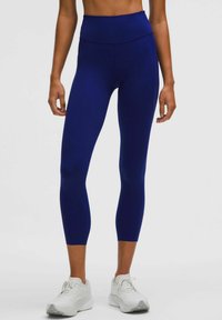Marinblå höga leggings gjorda av elastiskt material; formande design med en slät textur och ankellängd.