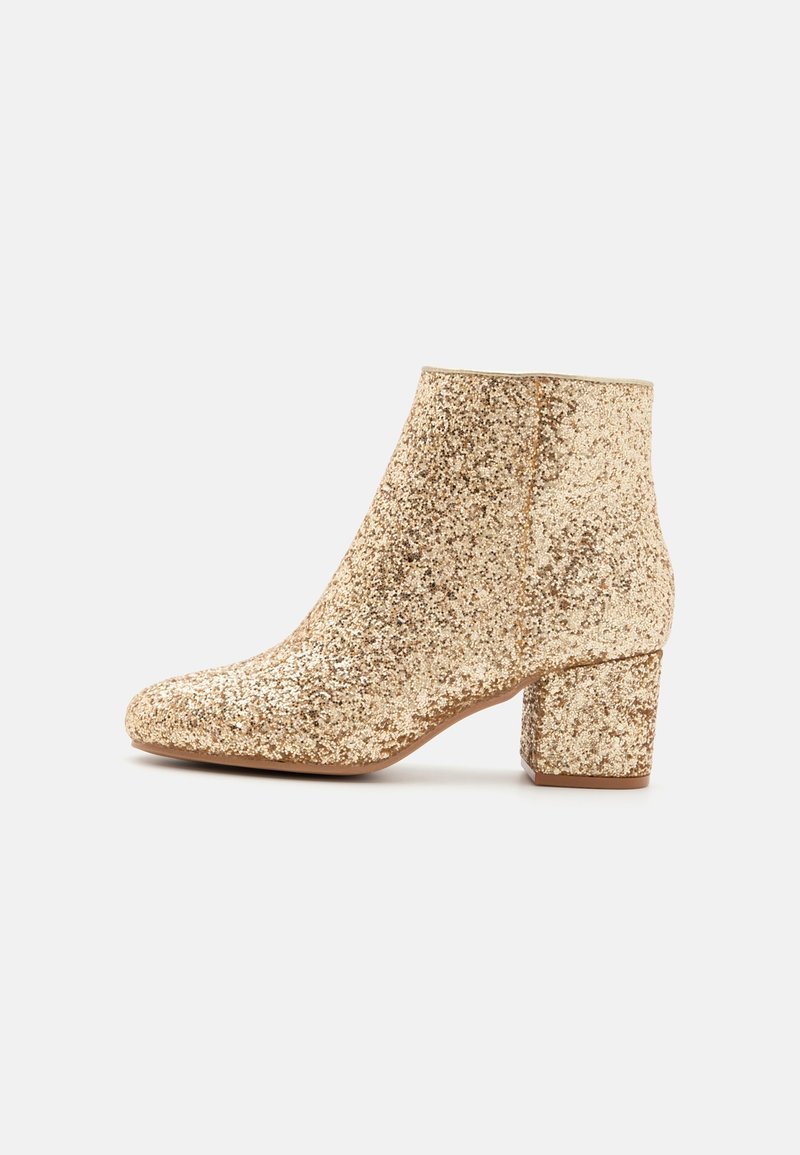 Bottine à paillettes dorées avec un talon bloc et un bout arrondi, vue de profil sur fond blanc.