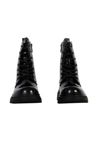 Zwarte gepatineerde leren veterschoenen met een ronde neus, dikke rubberen zool en decoratieve stiksels langs de zijkanten.
