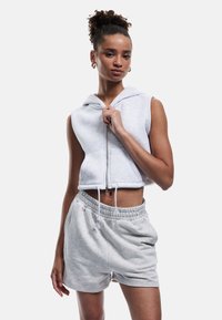 Gekürzter grauer Kapuzenpullover mit Reißverschluss und Kordelzug, kombiniert mit passenden grauen Shorts mit elastischem Bund und seitlichen Taschen.