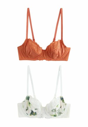 Divi krūšturi izstādīti: oranžs satīna krūšturis ar mežģīņu akcentiem un regulējamām siksnām virs balta krūštura ar ziedu rakstu, kas ir apvilkts ar mežģīnēm un izgatavots no mīksta auduma.