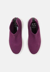 Purple slip-on sneakers with a ribbed knit upper, a white rubber sole, and a black pull tab at the heel. Features a logo on the side.
