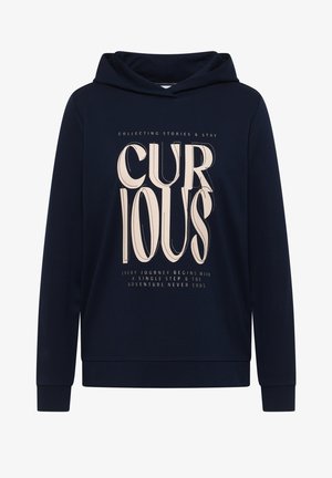 Tmavě modrá mikina s kapucí s nápisem „CURIOUS“ velkými krémovými písmeny a menšími frázi o cestě a dobrodružství pod ním.