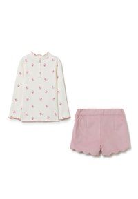 Langärmliges weißes Oberteil mit pinkem Blumendruck und gewelltem Saum, kombiniert mit kurzen Hosen mit gewelltem Saum in Pink. Weicher Stoff und einfache Knopfverschluss.