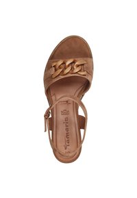 Tan suede sandal with a wide strap featuring a decorative chain link, an ankle strap, and a cushioned leather insole.