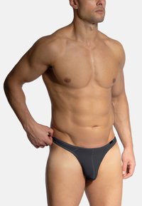Grau Herren-Thong aus weichem, dehnbarem Material. Verfügt über ein tief geschnittenes Design mit minimaler Abdeckung und subtilen Nahtdetails.