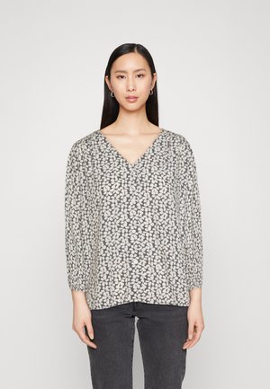 Grå V-halsbluse med blomstermotiv i kremfarge, lange ermer med rynkede mansjetter og løs passform. Myk tekstur i stoffet.