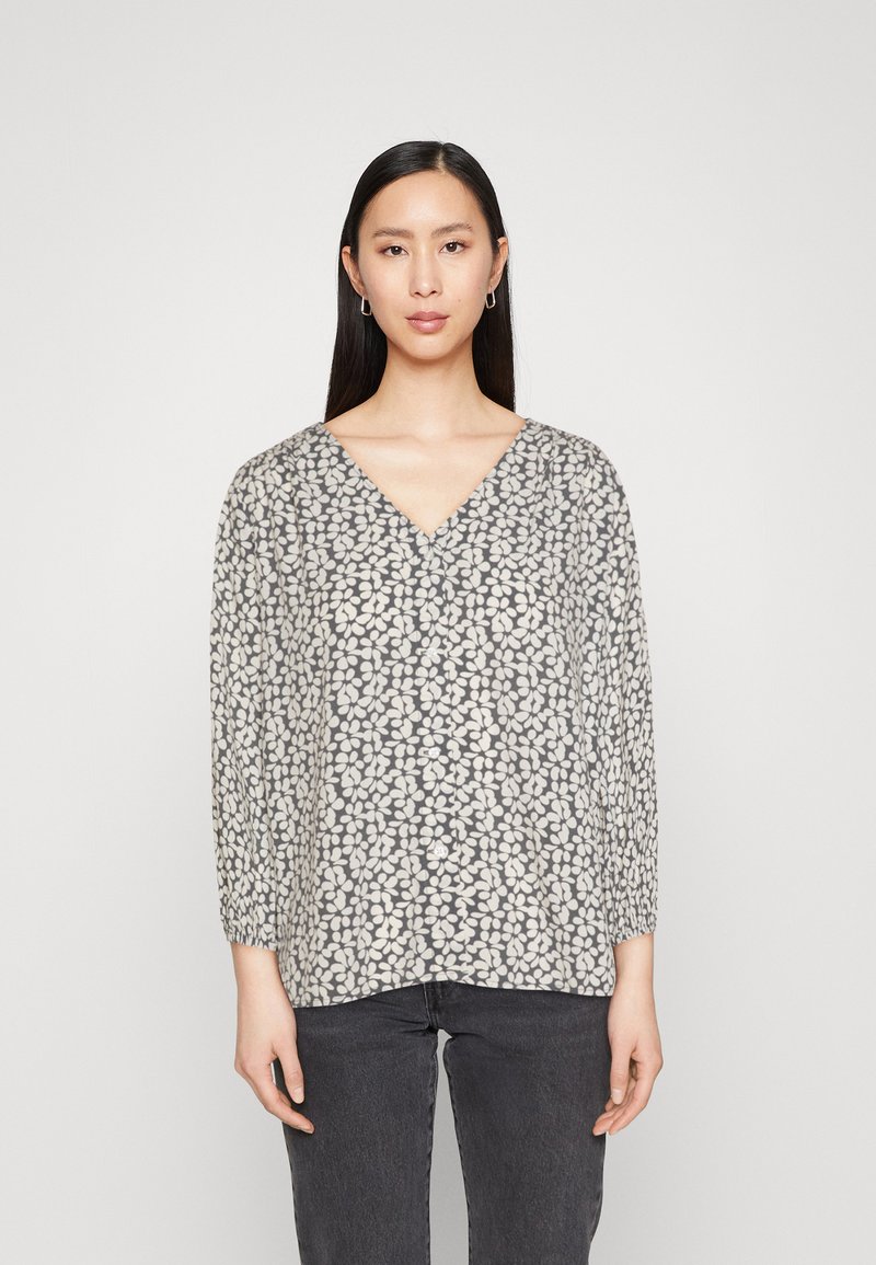 Grå V-halsbluse med blomstermotiv i kremfarge, lange ermer med rynkede mansjetter og løs passform. Myk tekstur i stoffet.