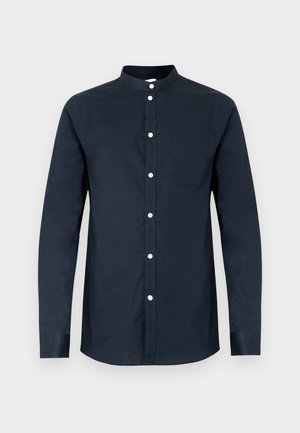 Chemise pour homme à manches longues de couleur bleu marine foncé, en coton, avec col mao, boutons sur le devant et une poche poitrine gauche. Texture lisse.