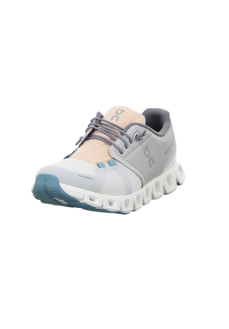 Zapatilla deportiva en gris y rosa pastel, con parte superior de malla, suela de goma, amortiguación destacada y un diseño dinámico en zigzag en la suela.