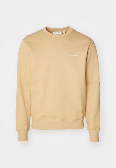 Beige színű pamut pulóver, kerek nyakkivágással, bordázott mandzsettákkal és aljjal, a mellrészen fehér színnel "TIGER OF SWEDEN" felirattal.