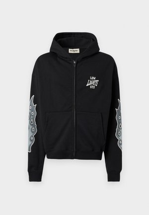Haut à capuche zippé noir en coton avec le texte blanc "LOW LIGHTS STD" sur la poitrine et un graphisme de tentacule de pieuvre en gris sur les deux manches.