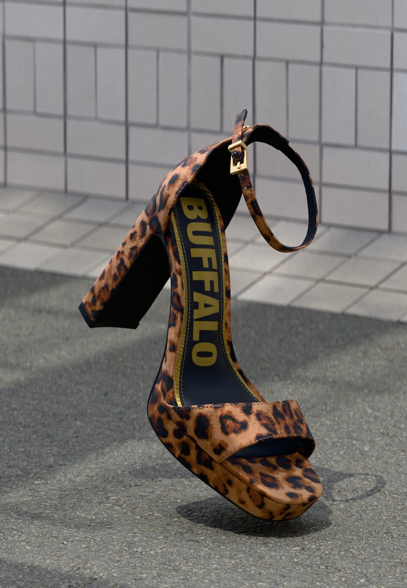 Zapato de tacón alto con estampado animal, tacón ancho, punta abierta y correa en el tobillo. Cuenta con una plantilla negra con "BUFFALO" en letras amarillas en negrita.