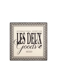 Négyzet alakú tálca, krémszínű háttérrel, fekete felirattal. A kockás szegély keretezi a "LES DEUX Goods" és az "EST 2011" feliratokat egy kis logóval.