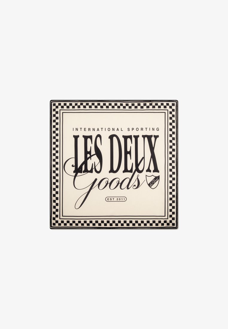 Prato quadrado com um fundo creme e texto em preto. Uma borda em padrão de tabuleiro de xadrez envolve "LES DEUX Goods" e "EST 2011" com um pequeno logótipo.