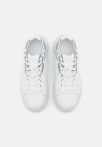 White sneakers featuring a smooth leather upper, gray accents on the sides, and a textured rubber sole, laced with white shoelaces.
