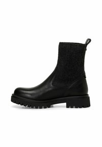Botín negro con cuero liso y parte superior de fieltro texturizado. Suela de goma gruesa con relieve profundo para agarre. Asa en la parte trasera.