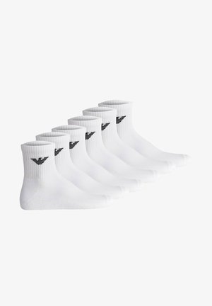 White cotton ankle socks, six pairs, featuring a ribbed texture and a black logo accent. Classic design suitable for various outfits.