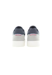 Marinblå och grå sneakers med en slät textur, vit sula och minimalistisk design. Har en röd och vit detalj på hälen.