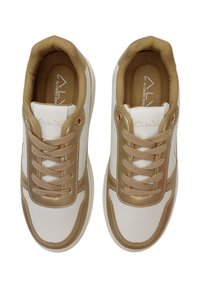 Scarpe da atletica bianche e dorate con tomaia liscia, colletto imbottito color tan e un accento testurizzato dorato sui lati. Design a punta rotonda.