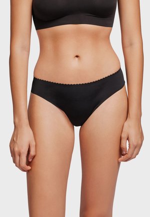 Zwarte bikini slipjes met een zachte textuur, voorzien van een gegolfde tailleband. Ontworpen voor een minimale bedekking.