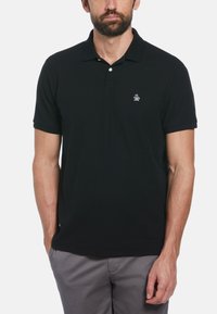 Black polo shirt made of cotton, featuring a three-button placket, short sleeves, and a small embroidered logo on the left chest.