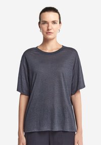 Blå kortärmad T-shirt i lätt material, som har en avslappnad passform och rundad halsringning. Slät textur med en subtil lyster.