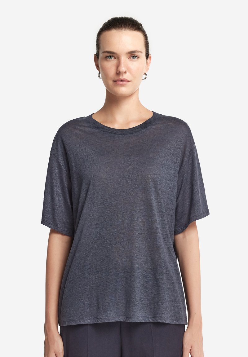 Blå kortärmad T-shirt i lätt material, som har en avslappnad passform och rundad halsringning. Slät textur med en subtil lyster.