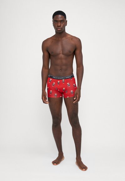 Boxeri roșii cu un model jucăuș de personaje de desene animate, având un tiv negru inscripționat cu "POLO RALPH LAUREN". Realizați dintr-un material moale.