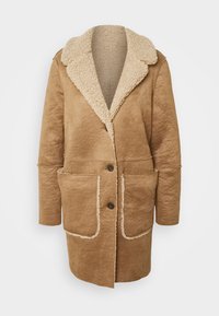 Cappotto in shearling beige con un esterno testurizzato, ampio colletto, chiusura frontale a bottoni e due tasche a toppa con bordo a contrasto.