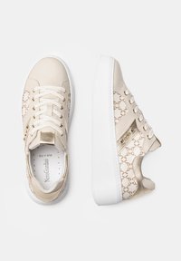 Beżowe sneakersy z gładką skórzaną cholewką i wzorzystymi tekstylnymi bokami. Biała gumowa podeszwa, złote akcenty i sznurowany design.