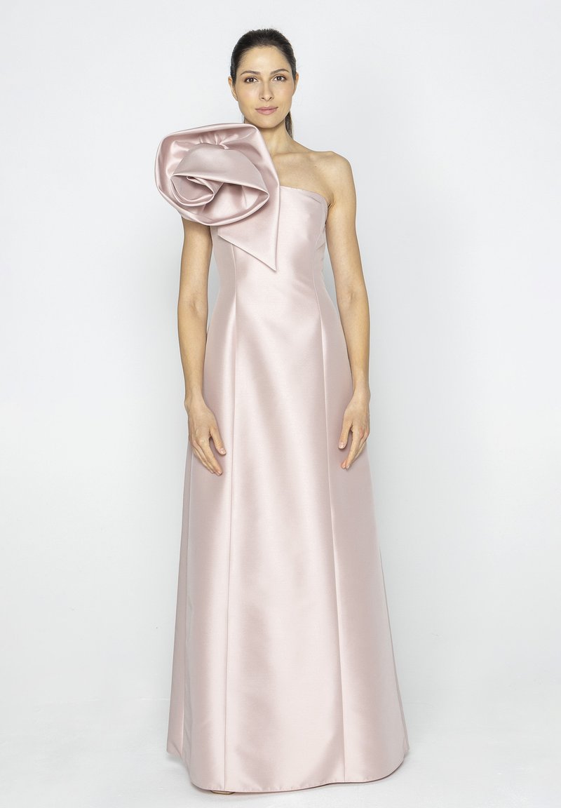 Różowa satynowa suknia wieczorowa z usztywnionym projektem na jednoramieniu i dużym kwiatowym akcentem na ramieniu. Gładka tekstura, długość do podłogi.