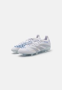 Scarpe da calcio bianche e grigie con dettagli blu, tomaia sintetica testurizzata, design di supporto e tacchetti trasparenti per la trazione.