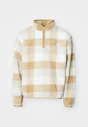 Pullover in pile con mezzi zip, caratterizzato da un motivo a quadri beige e bianchi e un piccolo logo sul petto. Tessuto morbido e vestibilità rilassata.