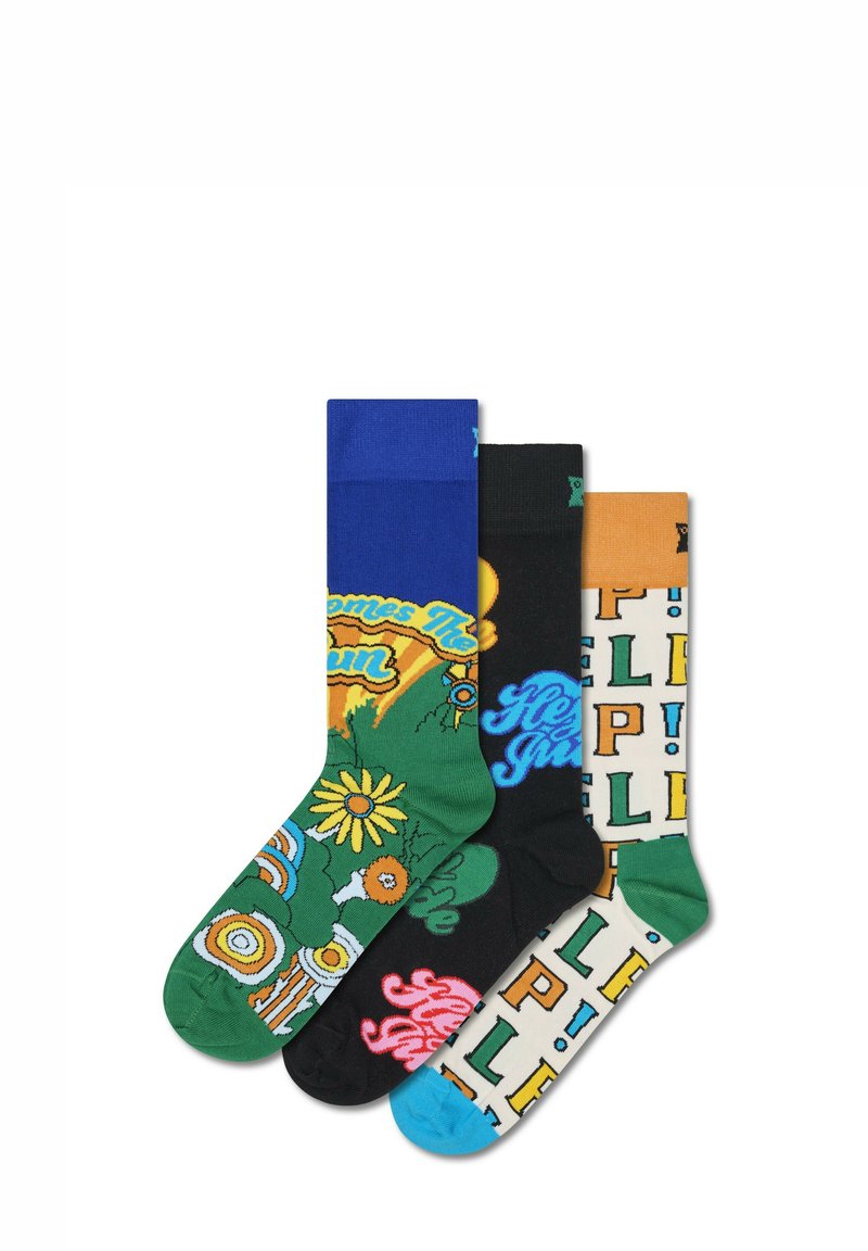 Trois paires de chaussettes colorées : bleues avec du texte, noires avec un motif floral et crème avec des lettres en blocs. Chaque chaussette présente des motifs distincts.