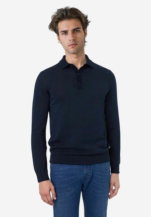 Navyblauwe langesleeve polo trui met een kraag, knoopsluiting, geribbelde manchetten en zoom, gemaakt van een gladde stof. Draagt met blauwe jeans.