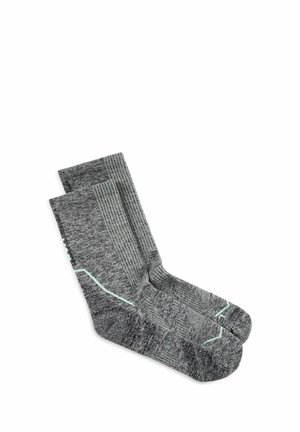Par de calcetines grises hasta la pantorrilla con textura acanalada y detalle de raya diagonal verde claro, colocados planos sobre fondo blanco.