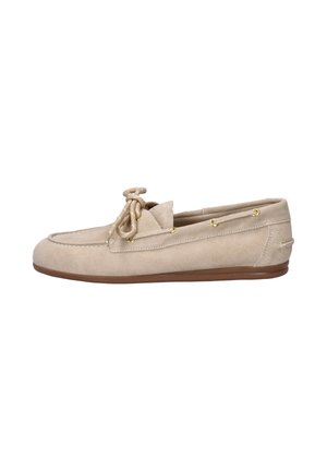 Beige suède loafer met bruine zool, ronde neus, gestikte details en decoratieve veter die in een strik bovenop is gebonden.