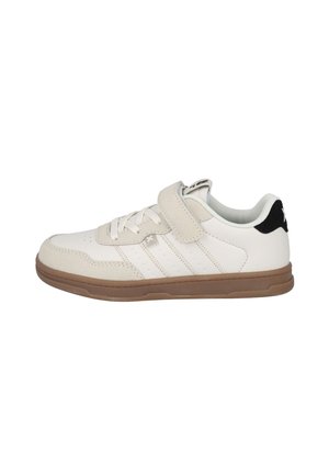 Zapatilla blanca de caña baja con detalles en ante beige, cordones blancos, una correa de velcro y suela de goma marrón, vista de perfil.