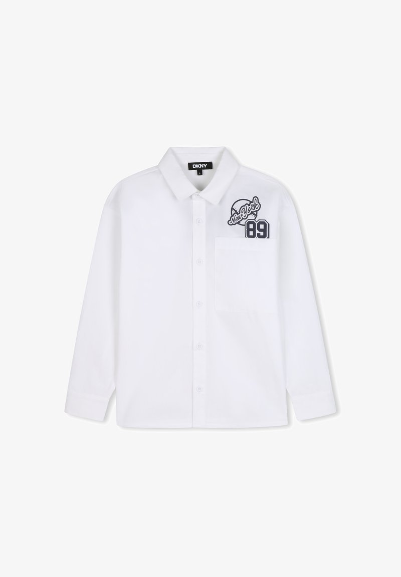 Chemise blanche à manches longues boutonnée avec poche avant et logo noir "New York 89" sur le côté supérieur gauche, étiquette DKNY à l'intérieur du col.