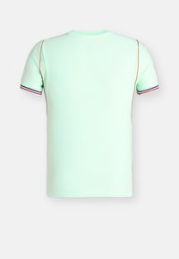 Gaiši zaļa īsroku T-krekls ar ribotu tekstūru, sarkani un zili apmales piedurkņu aprocēs un oranžas šuvju līnijas gar sāniem un pleciem.