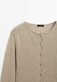 Cardigan en tricot beige avec un col rond, tissu texturé et une rangée de cinq boutons à l'avant. Détails de couture aux épaules.