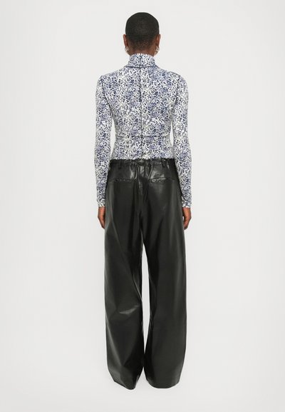 Fitted long-sleeve top with blue and white floral pattern, high collar; paired with wide-leg black leather pants, smooth texture.