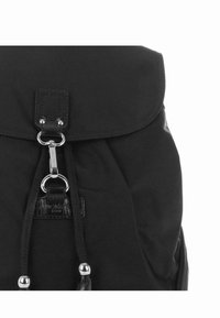 Sac à dos noir avec un tissu texturé, rabat supérieur et fermeture à cordon, orné de quincaillerie argentée brillante et d'une petite étiquette de logo.