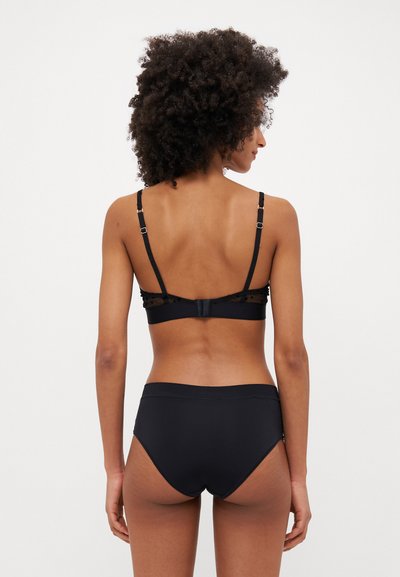 Conjunto de bikini negro con una tela suave. La parte superior tiene tirantes delgados ajustables y un diseño liso, mientras que la parte inferior ofrece una cobertura moderada.