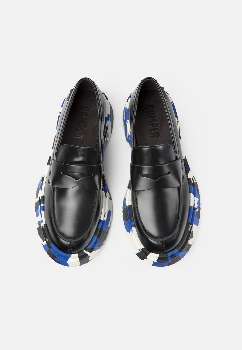 Czarne skórzane loafersy z akcentem w postaci kokardki, z kolorową, wzorzystą podeszwą w odcieniach niebieskiego, czarnego i białego. Widoczna teksturowana podszewka wnętrza.