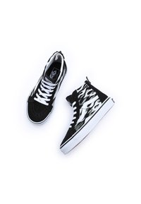 Hoge sneakers met een zwarte suède bovenkant, witte veters en vlampatronen in zwart en grijs aan de zijkanten. Witte zool en logo-accent.